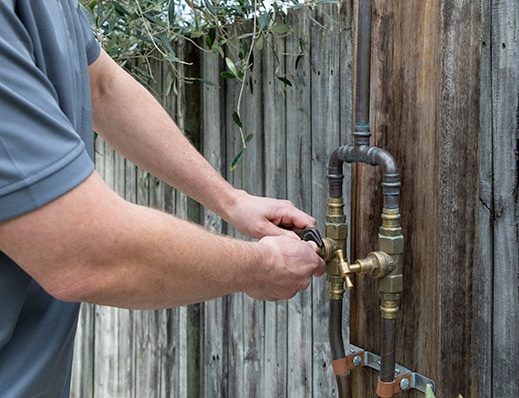 A Plumber Fixing the Outdoor Pipes in Sydney, NSW