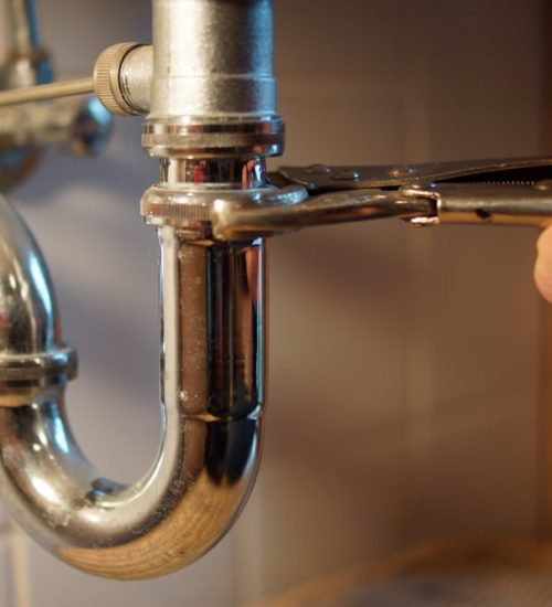 Plumbing Repair Service Professional Installer With Spanner Checking Pipe — Professional Plumbing Services in Willoughby, NSW