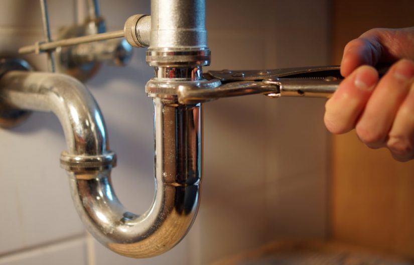 Plumbing Repair Service Professional Installer With Spanner Checking Pipe — Professional Plumbing Services in Willoughby, NSW